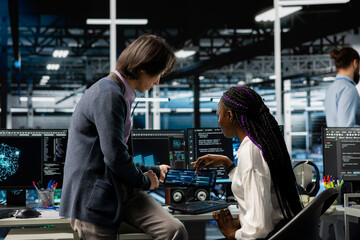 Team leader helping intern in data center to use AI LLM assistant to do maintenance on rigs. Manager and trainee doing internship in server hub, using large language model chatbot to do backups