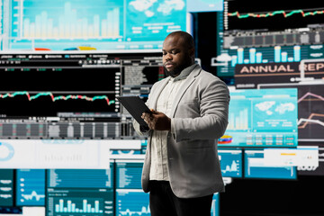 Young businessman thinking about a new solution to increase funds, evaluating statistics and...
