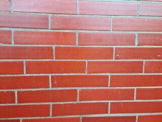 Smooth red brick wall with glossy surface texture
