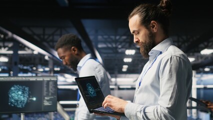 Server farm IT expert managing storage arrays supporting machine learning training workflows. Technician on industrial platform doing maintenance on rigs handling AI processing tasks