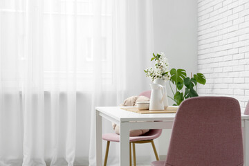 Interior of dining room with table and chairs near window