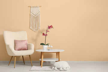Coffee table and armchair near beige wall in interior of room