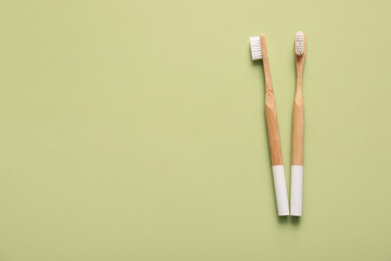 Wooden toothbrushes on green background