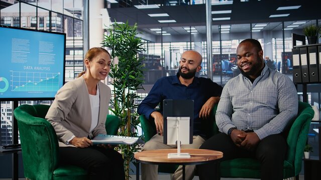 Group of professionals using remote communication tools for business meeting, focusing on strategy planning and investment discussions. Diverse organizational environment. Camera A.