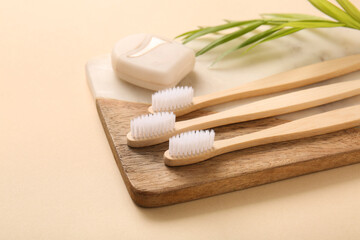 Composition with tray and wooden toothbrushes on beige background, closeup