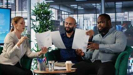 Diverse business professionals using analysis tools to extract details and insights for career growth and a collaboration for long term success story. Strong work ethic in office. Camera B.