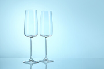 Empty champagne glasses on blue background