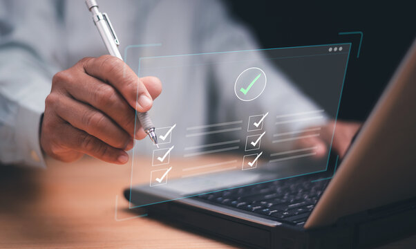 Digital checklist and task management concept. Businessman using pen marking completed items on a virtual screen. Productivity, project planning, workflow optimization and online business efficiency.