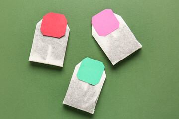 Tea bags with colorful labels on green background