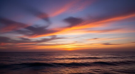 Dramatic sunset sky with vibrant orange and pink clouds over dark ocean waves