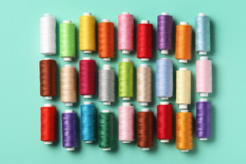 Set of different thread spools on mint background