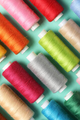 Set of different thread spools on mint background, closeup