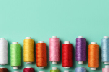 Set of different thread spools on mint background, closeup