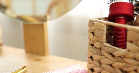 Hair styling. Different combs and brushes on wooden vanity indoors, closeup. Camera moving left