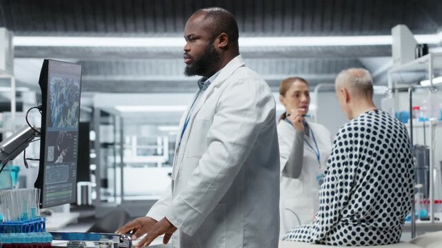 Black medic participates in laboratory drug study monitoring a patient during treatment testing, recording dosage and side effects. Evaluating pharmacology data for healthcare progress. Camera B.