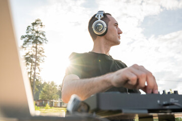DJ works in the backyard of a country house. 