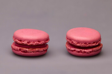 Two pink macarons side by side on gray background
