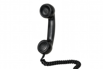 Black retro telephone handset with coiled cord, hanging, representing vintage communication and old technology