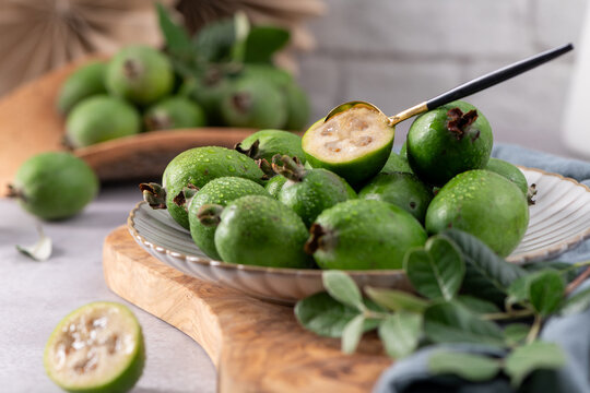 Fresh green feijoa fruit on a white plate