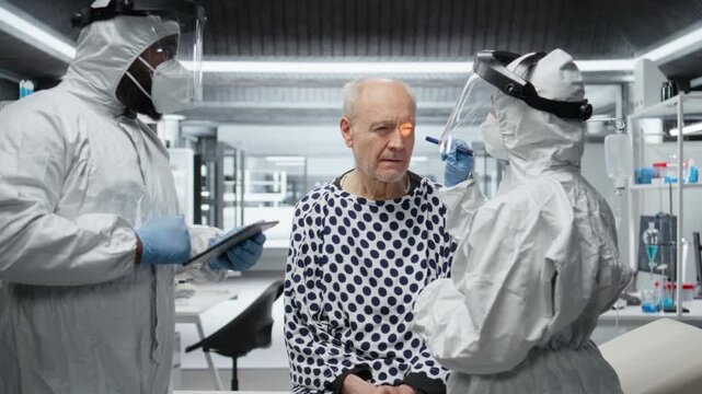 Scientists team in hazmat suit consults patient affected by a viral infection, analyzing symptoms, testing drug reactions and gathering pharmacology data for healthcare crisis prevention. Camera A.