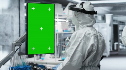 Vertical chroma key screen next to scientist in a biohazard facility treats a patient with infectious disease symptoms, study contamination control and vaccination methods for protection. Camera B. - Powered by Adobe