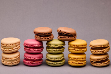 Six macarons in colorful arrangement on gray background