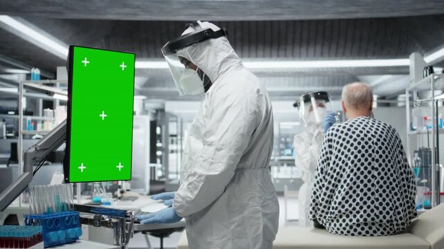 Medic looks at vertical green screen on monitor and observes patient reactions to antiviral treatment in a controlled laboratory setting. Vaccine development progress in prevention center. Camera A.