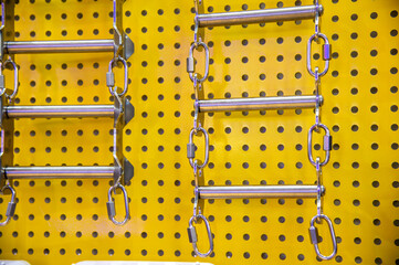A yellow wall with a ladder hanging from it