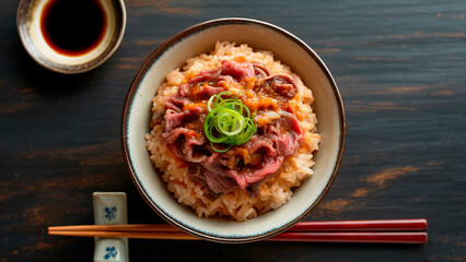 A photograph of a vibrant donburi bowl presented from a direct top-down perspective. Inside the ceramic bowl, a mound of fluffy, pearly white Japanese rice is topped with thinly sliced beef, glistenin