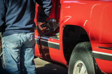 Man refueling red pickup truck at gas station in the United States © StockMediaSeller