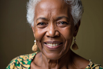 Beautiful close-up of a happy and wise senior black woman with grey hair smiling warmly and confidently