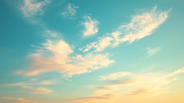Delicate Feathery Clouds Against a Tranquil Turquoise Sky with a Warm Golden Glow