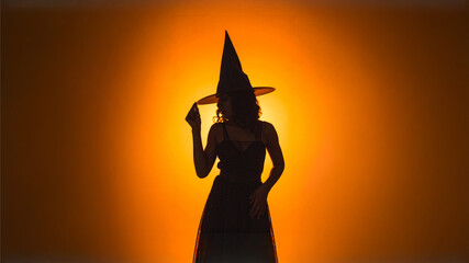 A Striking Silhouette of a Mysterious Woman in a Witch Costume Standing Boldly Against a Vibrant Orange Backdrop in High Quality Halloween Style