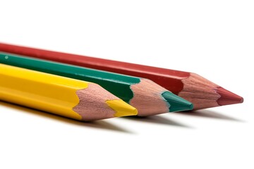 Three sharpened colored pencils in red green and yellow arranged diagonally on a white background