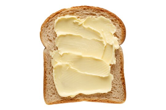 A single slice of whole wheat bread generously spread with creamy yellow butter on a white background