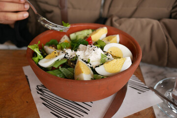 Fresh salad with eggs served in a rustic bowl