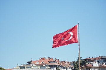 Turkish flag waving over city buildings on a clear day