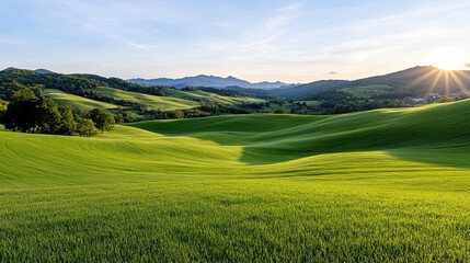 Naklejka premium Lush green hills under golden evening sky create serene landscape, evoking peace and tranquility