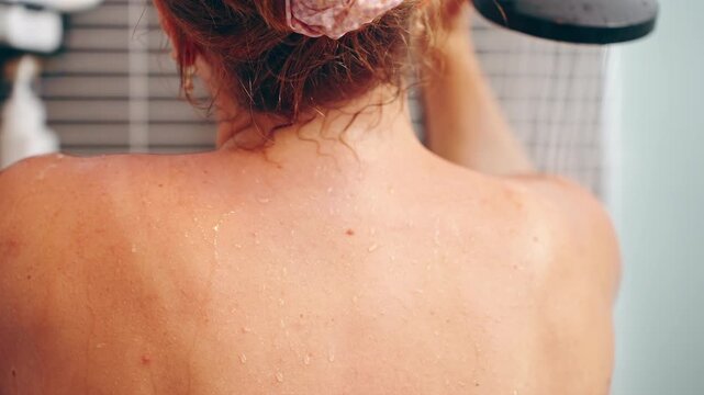 Wet Back of Woman Standing Under Shower Stream with Hand Resting on Shoulder, Steam and Droplets Visible, Relaxation and Wellness Concept