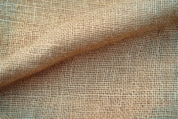Close-up of textured beige burlap fabric with visible weave pattern and soft folds creating a natural and rustic appearance