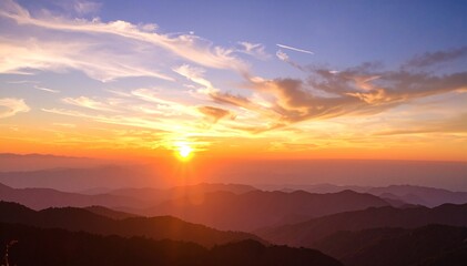 A breathtaking sunset paints the sky in vibrant hues of orange, pink, and purple, casting a warm glow over majestic mountains and rolling hills.