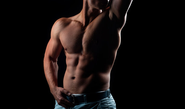 Mans powerful shoulders. Chest muscles. Muscular shirtless manked man model showing strong shoulders, bare chest. Gay sexy model.