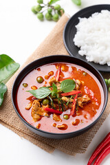 Thai red curry with pork and cooked rice with ingredients on white background