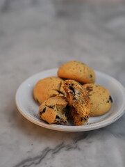 Golden cookies with melty chocolate, one broken to reveal soft interior