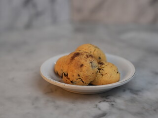 Golden cookies with melty chocolate, one broken to reveal soft interior