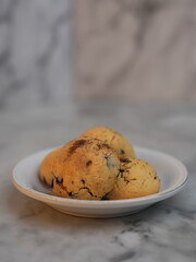 Golden cookies with melty chocolate, one broken to reveal soft interior