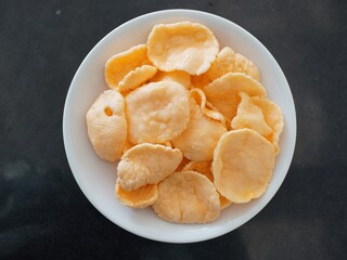 Crispy prawn crackers (Krupuk Udang), a traditional Indonesian snack, in a white bowl.