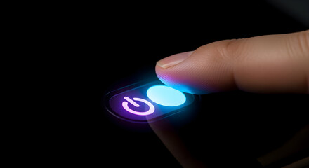 Finger presses glowing power button on dark background