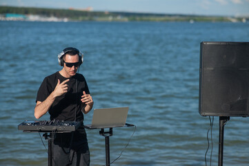 Male DJ playing music on the beach. 