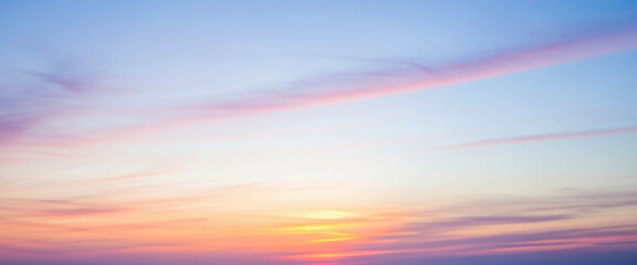 Blurred pastel sky colors during sunset or sunrise with faint clouds floating gently, blending warm and cool tones that evoke serenity, romance, and the soft transition between day and night.